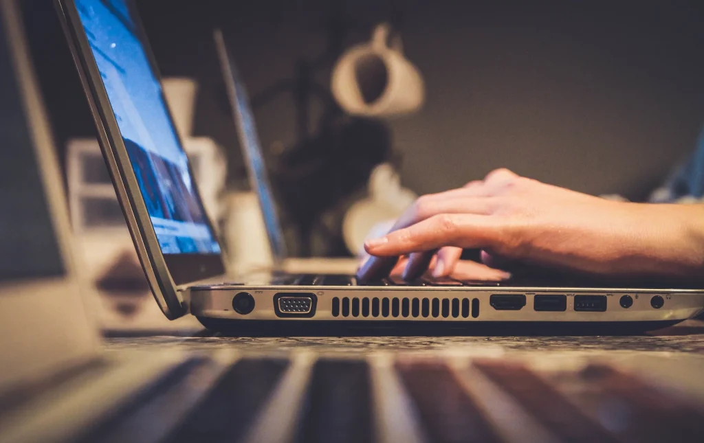 Man working on the laptop, writing his resume.