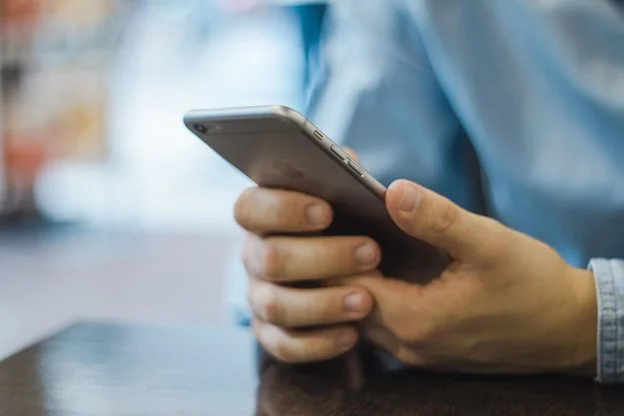 Man with a phone in his hands, deciding how to answer it.