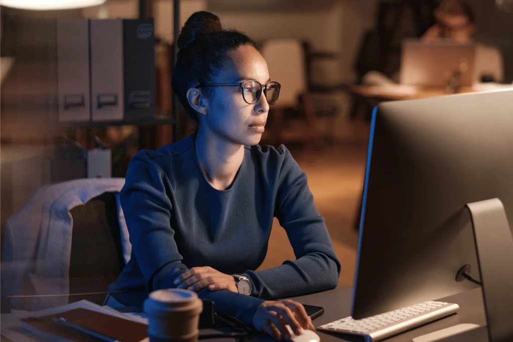 Woman looking at laptop in quite office setting.
