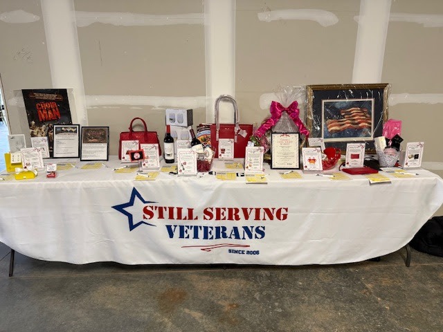 Silent auction table at the Baldwin Group and Aurex Whiskey Night benefiting Still Serving Veterans.