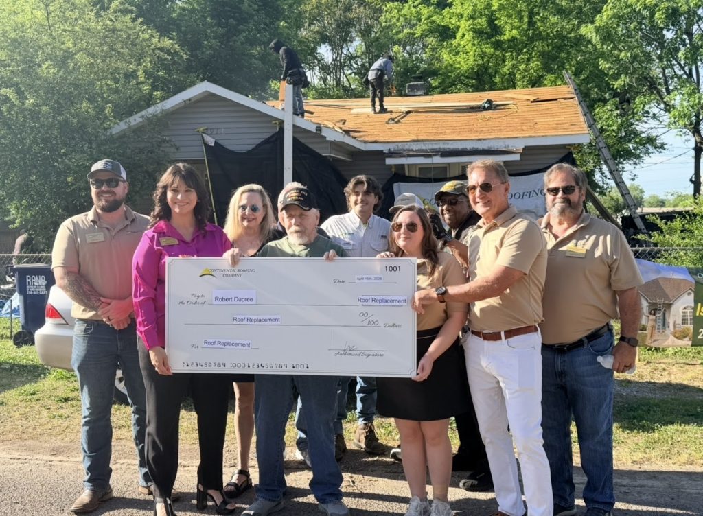 Continental Roofing team presenting roof replacement award check to a veteran.